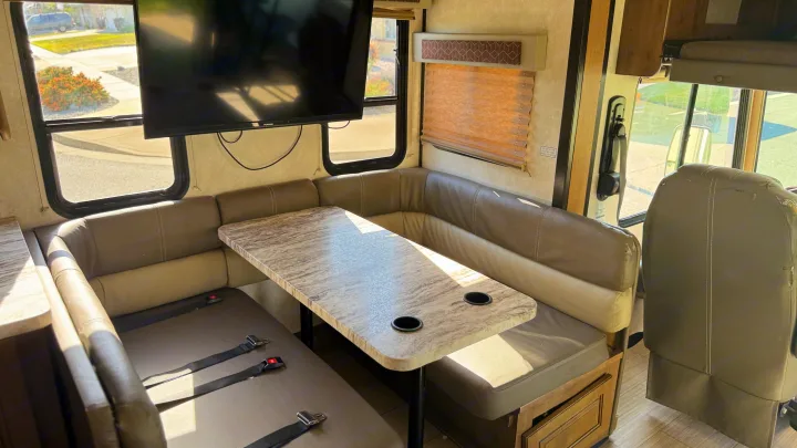 Booth dinette facing the couch with a TV above